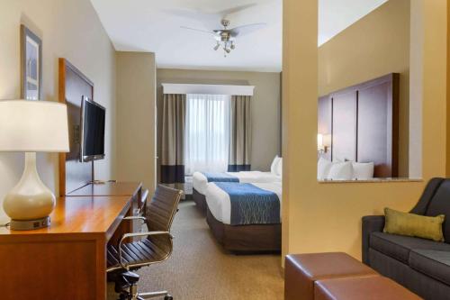 a hotel room with a bedroom with a bed and a couch at Comfort Inn & Suites Amarillo East in Amarillo