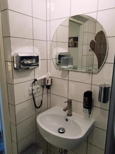 a bathroom with a sink and a mirror at Bölsche Hotel in Berlin
