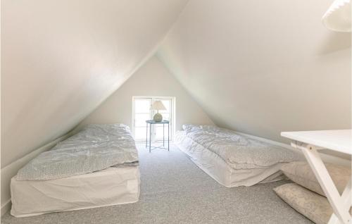 a bedroom with two beds and a table at Strandhytten in Allinge
