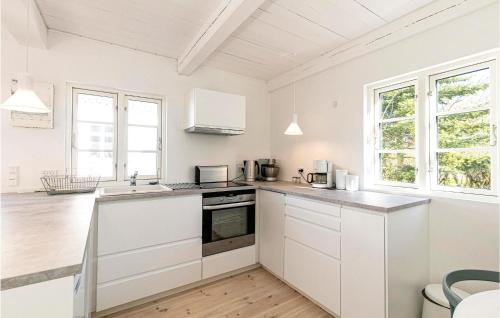 a kitchen with white cabinets and a counter top at Strandhytten in Allinge