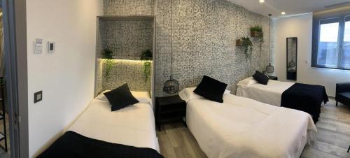 a room with two beds and a brick wall at Hotel Riojano in Humanes de Madrid