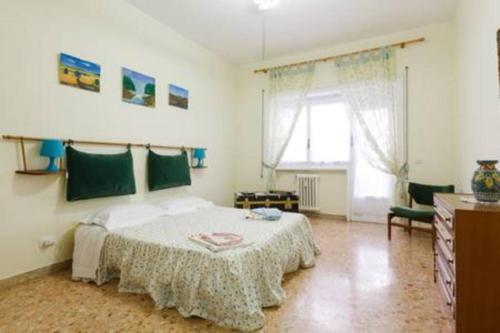sypialnia z dużym łóżkiem i oknem w obiekcie Bea Home sarai il benvenuto! w Rzymie