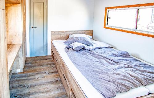 uma cama num pequeno quarto com uma janela em Stunning Ship In Hennigsdorf With Lake View em Hennigsdorf