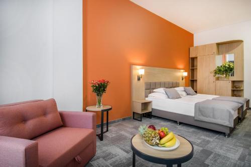 ein Hotelzimmer mit einem Bett und einem Tisch mit einer Obstschale in der Unterkunft Hotel Split Inn by President in Split