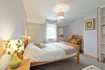 um quarto com uma cama e um vaso sobre uma mesa em Ash House Bed and Breakfast em Calverstown