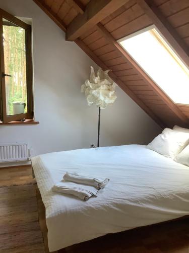 um quarto com uma cama branca e uma janela em Villa & Jacuzzi nad rzeka Wkra em Goławice
