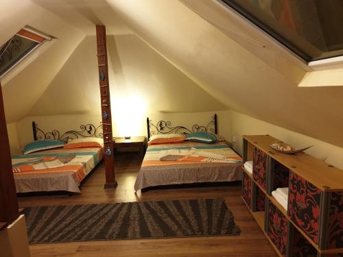 two beds in a room with a attic at Porto Lima in Limanu