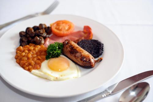 a plate of food with eggs sausage beans and tomatoes at Royal Hotel in Bath