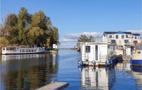 dos barcos están atracados en el agua junto a las casas en Stunning Apartment In Rechlin With Wifi, en Rechlin