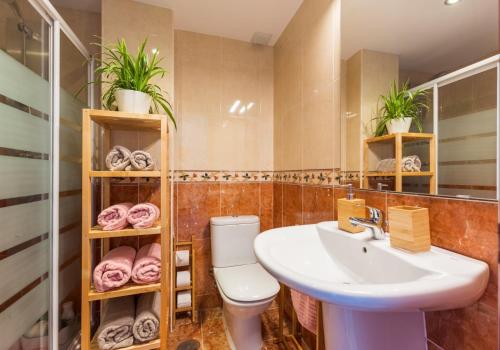La salle de bains est pourvue d'un lavabo et de toilettes. dans l'établissement Bonito Apartamento en Primera Línea de Playa, à Estepona