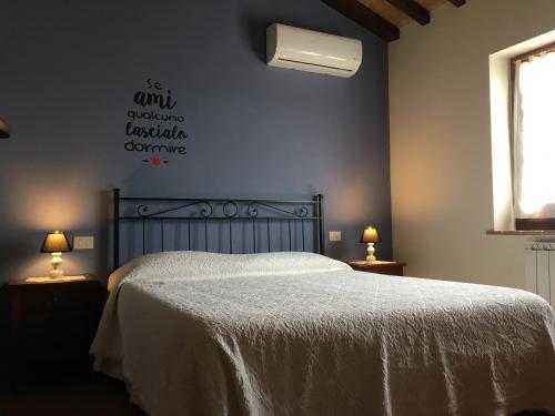 a bedroom with a bed with a white bedspread at Agriturismo Tenuta Badia in Paciano