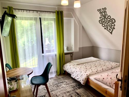 ザコパネにあるWilla Widokowa Zakopaneの小さなベッドルーム(ベッド1台、テーブル、椅子付)