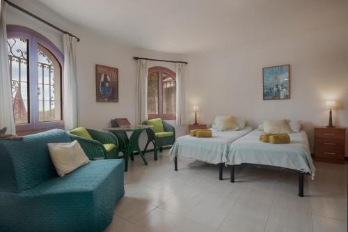 コンペタにあるVilla Andaluciaのベッド2台、椅子、テーブルが備わる客室です。
