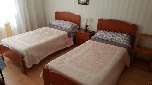 a bedroom with two beds and a dresser at HOSTAL BODEGÓN A COSECHA in San Ciprián