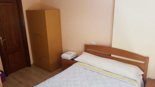 a small bedroom with a bed and a wooden cabinet at HOSTAL BODEGÓN A COSECHA in San Ciprián