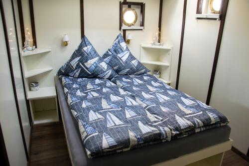 a bed with pillows on it in a room at Island-dreams Hausboot Cecilie in Schleswig