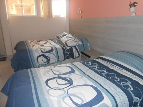 a bedroom with two beds with black and white sheets at Le Ciel d'Uyuni in Uyuni