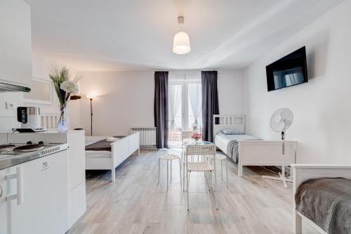 a living room with a kitchen and a bedroom at Pod Winogronem - Apartamenty z basenem i wyżywieniem in Pobierowo