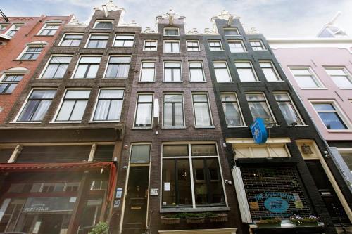 
a building with a clock on the side of it at Quentin Golden Bear Hotel in Amsterdam
