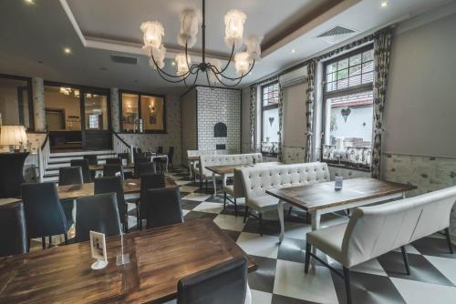 a restaurant with tables and chairs and windows at Medical Wellness & SPA Werona in Duszniki Zdrój