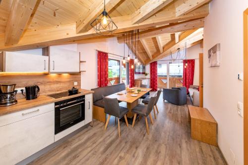 eine Küche und ein Esszimmer mit einem Tisch und Stühlen in der Unterkunft Elto Appartements Chalet in Kaprun