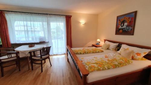 a bedroom with two beds and a table and a dining room at Gästehaus Casa Cristina in Bad Krozingen