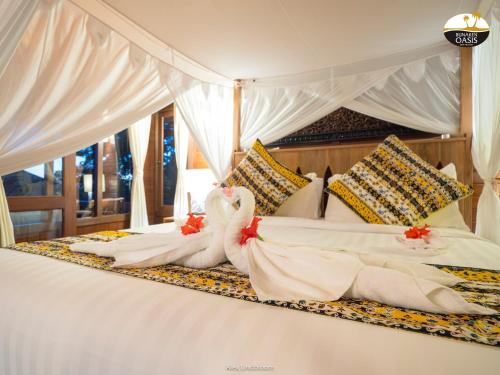 dos cisnes están sentados en la parte superior de una cama en Bunaken Oasis Dive Resort and Spa en Bunaken