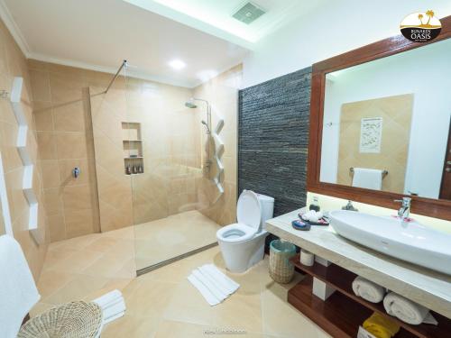 y baño con aseo, lavabo y ducha. en Bunaken Oasis Dive Resort and Spa en Bunaken