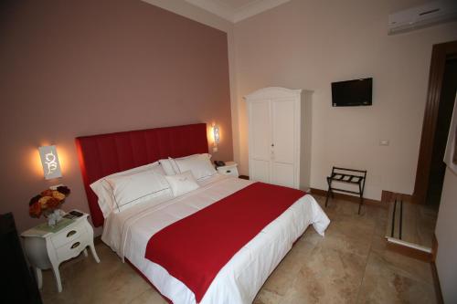 a bedroom with a large bed with a red headboard at B&B Milu' in Crotone