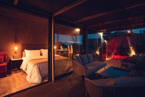 a bedroom with a bed and two chairs on a deck at Charm Nature in Azoia