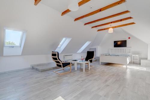 a white living room with a table and chairs at Pod Winogronem - Apartamenty z basenem i wyżywieniem in Pobierowo