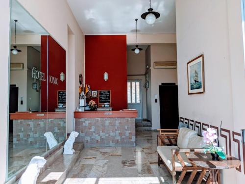 un vestíbulo con una pared roja y un bar en Hotel Ionio, en Katakolon