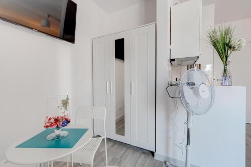 a white room with a table and a fan at Pod Winogronem - Apartamenty z basenem i wyżywieniem in Pobierowo