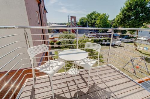 a patio with a table and chairs on a balcony at Pod Winogronem - Apartamenty z basenem i wyżywieniem in Pobierowo