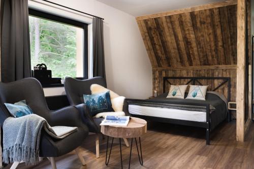a bedroom with a bed and chairs and a window at Tatra Loft in Zakopane
