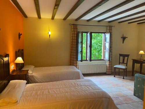 1 dormitorio con 2 camas y ventana en Posada San Pedro, en Oreña