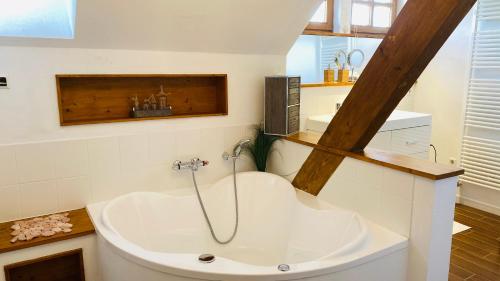 a bathroom with a bath tub and a sink at Ferienwohnung am Golfplatz in Scheidegg