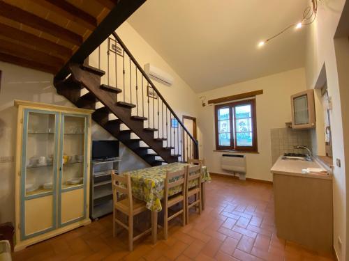 a kitchen and dining room with a spiral staircase at Agriturismo Tenuta Badia in Paciano
