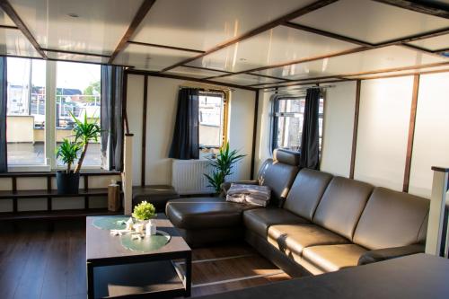 a living room with a couch and a table at Island-dreams Hausboot Cecilie in Schleswig