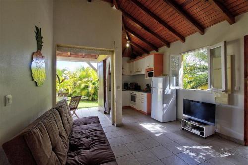 a living room with a couch and a kitchen at Domaine De Berard in Sainte-Anne
