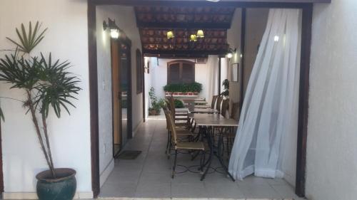 a patio with a table and chairs in a building at Pousada L'étage in Búzios