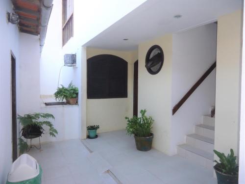 a hallway of a house with potted plants and stairs at Pousada L'étage in Búzios
