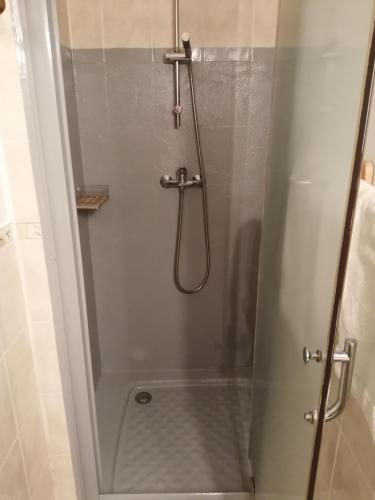 une douche avec une porte vitrée dans une salle de bain dans l'établissement Chambres et Gîte Peyroutas 