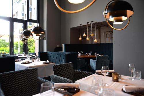 a restaurant with tables and chairs and chandeliers at Radisson Blu Senator Hotel, Lübeck in Lübeck