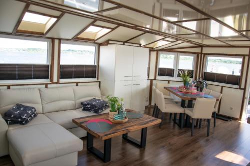 a living room with a couch and a table at Island-dreams Hausboot Cecilie in Schleswig