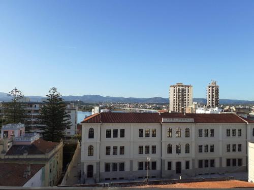 a white building with a red roof in a city at Marysel Rooms in Olbia