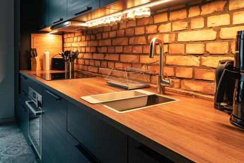 a kitchen with a sink and a brick wall at Das Sterf in Willershagen