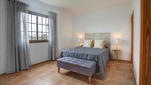 1 dormitorio con 1 cama, 1 silla y 1 ventana en Villa Elena, en Lajares