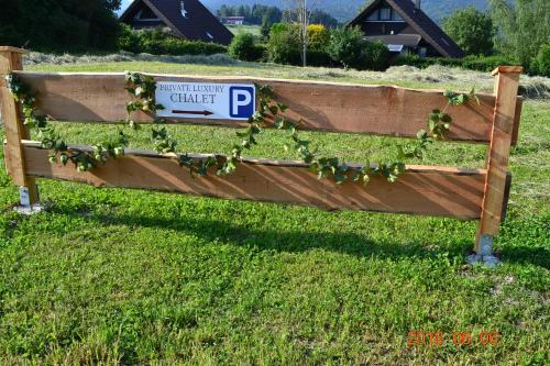 Ein Schild auf einem Zaun, auf dem Efeu wächst. in der Unterkunft Private Luxury Chalet in Siegsdorf