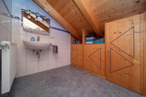 ein Badezimmer mit Waschbecken und Holztür in der Unterkunft Apartment Anda in Garmisch-Partenkirchen